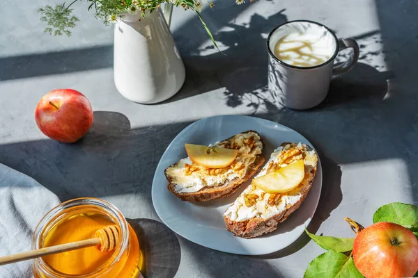 Rebanadas de pan con requesón, miel, manzanas y nueces en el plato. Concepto de desayuno — Foto de Stock