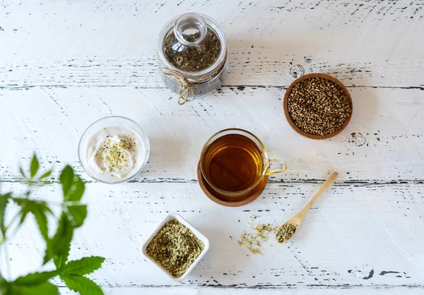 Prodotti di canapa: tè, semi sgusciati e interi, yogurt con semi, pianta di cannabis — Foto Stock
