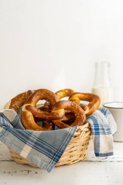 Sütlü peçeteli ekmek sepetinde Brezels veya pretzels