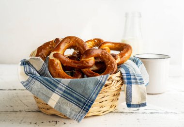 Sütlü peçeteli ekmek sepetinde Brezels veya pretzels