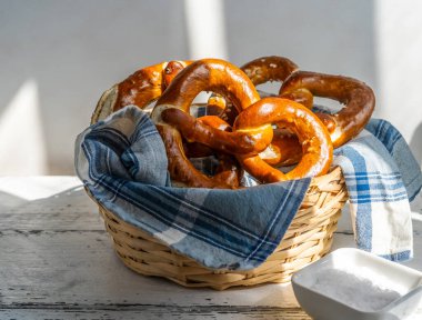 Peçete ve tuzlu ekmek sepetinde Brezels veya pretzels. Güçlü gölgeler