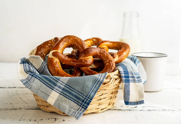 Sütlü peçeteli ekmek sepetinde Brezels veya pretzels