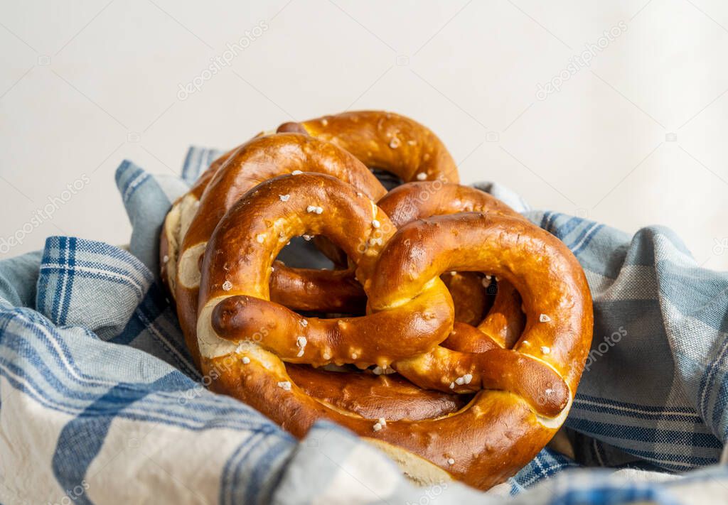 Group of brezels or pretzels in bread basket with napkin 
