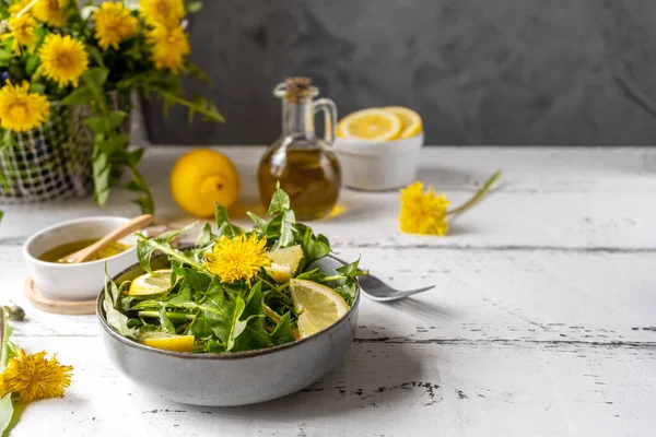 Salată de păpădie cu ulei de măsline, suc de lămâie și condimente pe masă albă din lemn cu fundal gri. Copiați spațiul — Fotografie, imagine de stoc