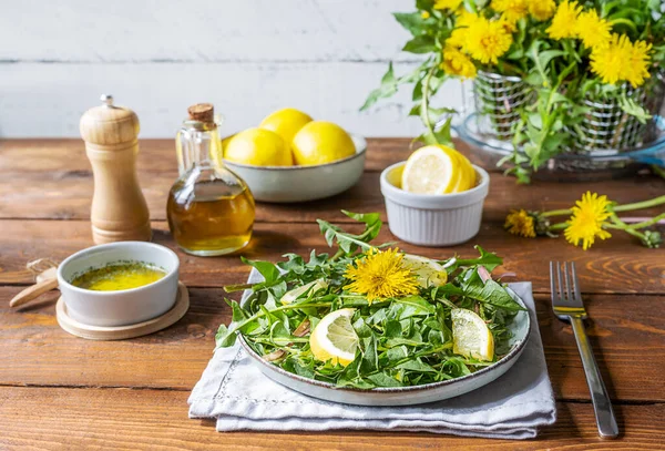 Salada de dente de leão com molho feito com azeite, suco de limão e especiarias na mesa de madeira marrom. — Fotografia de Stock