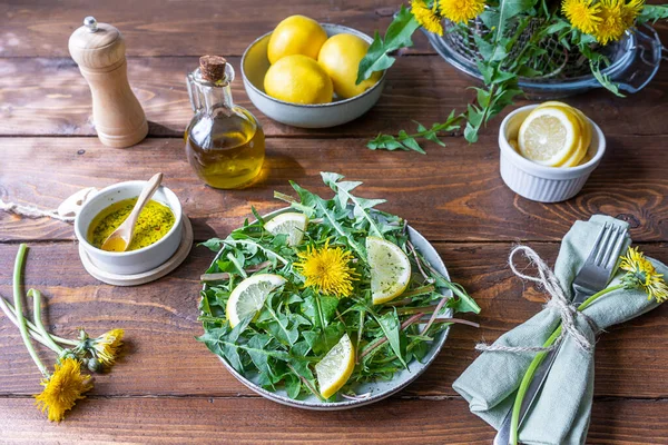 Karahindiba salatası zeytin yağı, limon suyu ve kahverengi ahşap masadaki baharatlardan yapılır..