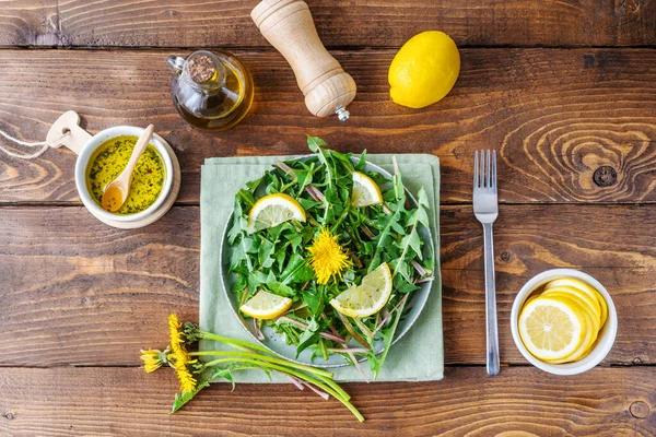 Dandelion salad with dip made with olive oil, lemon juice and spices on brown wooden table. Top view — Fotografie, imagine de stoc