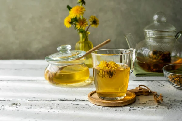 Dandelion honey and tea on the white wooden table with tea pot, dandelion flowers, dry herbal mix for infusion — Foto de Stock