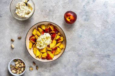 Nektarinli sağlıklı meyve salatası, şam fıstığı ve baldan yapılmış ricotta kreması. Somut bir geçmiş. Temel malzemeler. Düz yatıyordu. Boşluğu kopyala