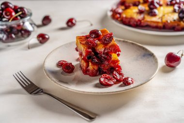 Tatlı vişneli turta mı yoksa çikolatalı kek mi? Bir parça tabak, kek ve çiğ kiraz. Seçici odak