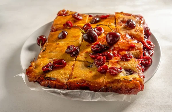 Taze pişmiş vişneli turta ya da beyaz arka planda kırmızı browni keki. Seçici odaklanma. Kapat.