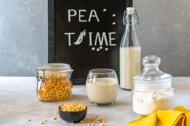 Vegan Sağlıklı Bezelye Ürünleri - süt, un ve tohum. Sarı peçete, maket alanı. Somut arkaplan. 