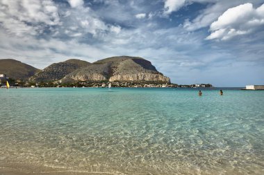 Mondello Körfezi 'nin panoramik manzarası, plaj, banyo ve kendi kendine yüzme. Kristal berrak deniz, koreografik bulutlu mavi gökyüzü