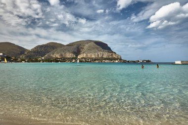 Panoramic view of the Gulf of Mondello, beach, bathers and self sailing. Crystal clear sea, blue sky with choreographic clouds clipart