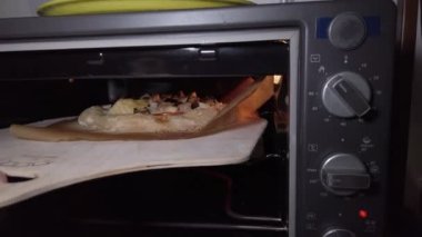 Ev yapımı bir pizza pişir. İçinde un, dilimlenmiş domates, mozzarella, patlıcan, enginar, mantar ve sosis olsun..