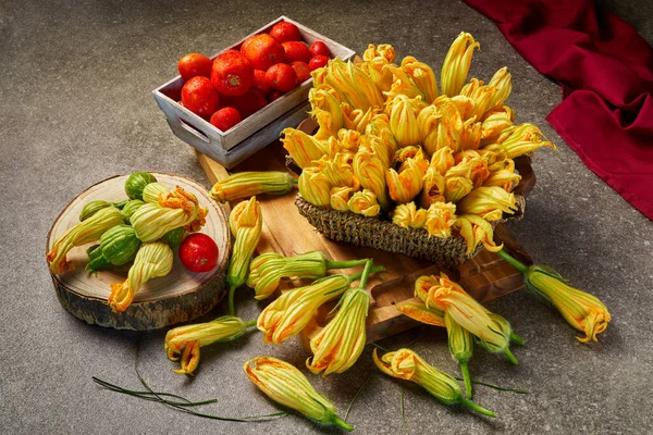 Freshly picked courgette flowers, tomatoes and small courgettes with flowers