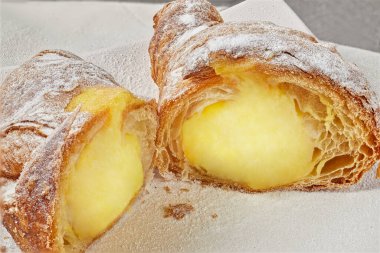 Limon sarısı kremalı sıcak kruvasan, kremayı görmek için ikiye böl.