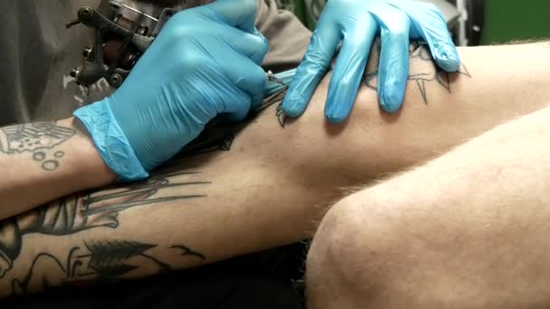 纹身大师的东西客户腿上的纹身 — 图库视频影像