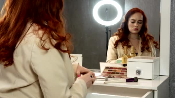 Schöne Rothaarige Mädchen Sitzt Vor Einem Spiegel — Stockvideo