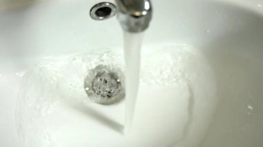 flow of water from the faucet flowing into the sink