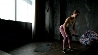 beautiful girl doing a hand exercise with dumbbells