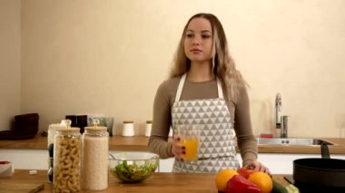 beautiful girl drinks juice while in the kitchen