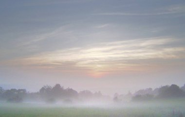 Sonbahar doğasının rüya gibi havası, batan güneş bulutlu gökyüzü ve yer sisi ile mücadele ediyor..