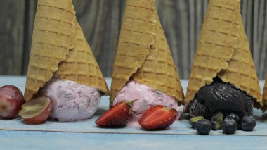 Masanın üzerinde bir bardak böğürtlen olan dondurma.