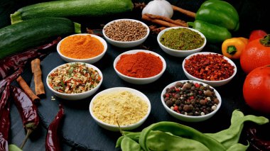 Masanın üzerinde farklı baharatlar olan tabaklar.