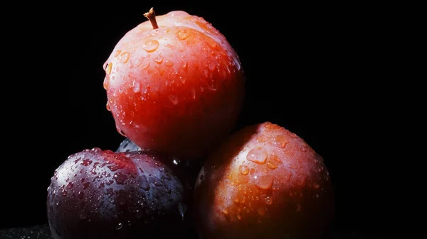 siyah bir zemin üzerine üç Erik