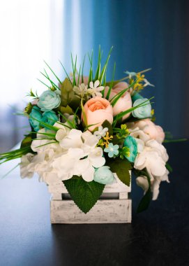 Masadaki güzel çiçekler koyu bir arka planda. Yapay.