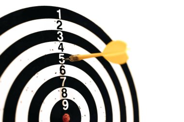 Sarı dart hedefi beş numarayla vurdu. Başarısız bir atış. Kazanma arzusu. Seçici odak.