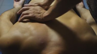 Kuafördeki kas sporcusuna masaj yapan bir masaj uzmanının kolları. Profesyonel masajcının erkek eli. Salondaki sporcunun omuz masajı. Sağlıklı yaşam tarzı kavramı