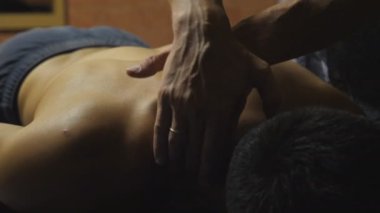 Masajcının erkek kolları kuaförde sırt masajı yapıyor. Profesyonel masör. Salondaki kaslı sporcunun omzuna masaj yapıyor. Sağlıklı yaşam tarzı kavramı. Yavaşça kapat.