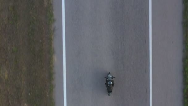 Вид сверху на езду байкера на современном спортивном мотоцикле по шоссе. Мотоциклист гоняет на мотоцикле по асфальтовой дороге. Человек в шлеме водит велосипед во время поездки. Концепция свободы и приключений. Воздушный удар — стоковое видео