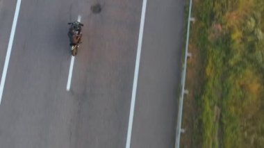 Yolculuk sırasında motosiklet kullanan motorcuya en iyi manzara. Adam otoyolda modern spor motosikletle hızlı gidiyor. Motosikletli, kır yolunda bisikletiyle yarışıyor. Yolculuk ve macera kavramı. Hava görüntüsü