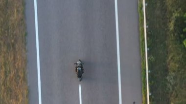 Motosikletli yarışçıların en iyi manzarası güneşli bir günde otoyolda motosikletiyle yarışır. Country Road 'da motosikletle gezen bir adam. Yolculuk sırasında bisiklet süren adam. Yolculuk ve özgürlük kavramı. Hava görüntüsü