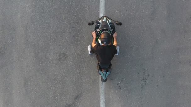 Vista superior do motociclista realizando burnout pneu com muita fumaça. Roda de motocicleta são deslizamento na rota durante o início do movimento. Roda de moto esporte começa a girar na estrada de asfalto. Movimento lento Tiro aéreo — Vídeo de Stock