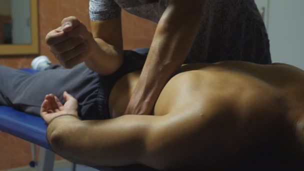 Massagista profissional massageando nádega de desportista com o cotovelo na sala de estar. Massagista relaxante e revitalizante músculos do atleta após o treinamento duro. Conceito de estilo de vida saudável. Movimento lento — Vídeo de Stock