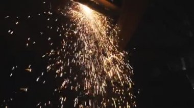 Birçok parlak kıvılcım plazma kesimi sırasında sıcak metalden uçar. Lazer kesici çalışıyor. Endüstriyel metal üretimi. Çelikten bir eser üretmek. Atölyede detayları anlatıyorum. Yavaş çekim