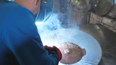 Kaynakçı metal işleriyle uğraşır. Endüstriyel üretimde koruyucu maske kaynak işçisi. Çelik gibi ağır işçilik. Erkek, ağır iş. Garajda veya metal fabrikasında çalışan bir zanaatkar.