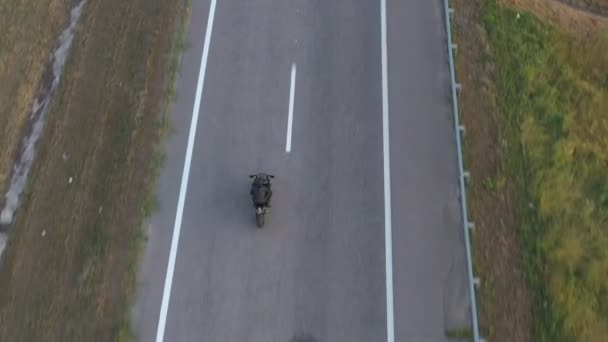 在公路旅行中,骑摩托车的人最受欢迎.人们骑着现代摩托车在高速公路上飞驰而去.骑摩托车的人在乡间路上骑自行车.旅行和冒险的概念。空中射击 — 图库视频影像
