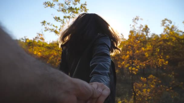 Jeune femme tient la main masculine et fait du jogging le long du chemin dans le jardin. Suivez-moi photo de fille heureuse tire son petit ami le long de la piste à travers les petits chênes. Belle nature en arrière-plan. Concept d'amour. Point de vue — Video