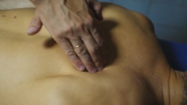 Salondaki genç bir sporcunun masaj yapan profesyonel masör kollarının üst görüntüsü. Masajcı sıkı eğitimden sonra sporcunun kaslarını gevşetiyor ve canlandırıyor. Sağlıklı yaşam tarzı kavramı