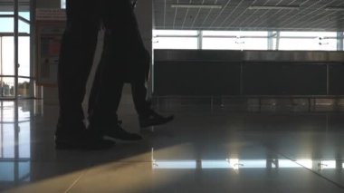 İki işadamları Havaalanı terminalinde yürüyüş metrelik. Bacaklar birlikte adım iş adamlarından. Meslektaşları kapalı olacak. Ağır çekim düşük görüş açısı yakın çekim