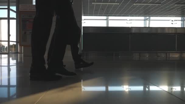 Ноги двох бізнесменів, що ходять у терміналі аеропорту. Ноги бізнесменів крокують разом. Колеги ходять у приміщенні. Повільний рух Низький кут зору Крупним планом — стокове відео