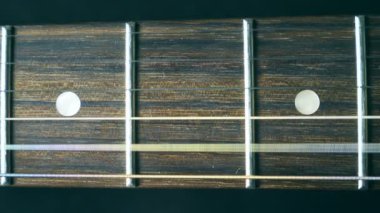Çalma sırasında titreşimli gitar dizenin kapatın. Kordon strummed ve titreşimle görüyorum. Perde karşı titriyordu. Güzel ahşap dokulu arka plan. Müzik performans. Ağır çekim