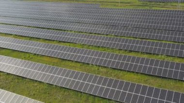 Aerial view of solar panel farm generating electricity. Rows of energy solar panels installed on farmland meadow or rural field. Concept of ecology and renewable green energy. Top shot