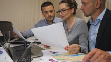 İş arkadaşları, ofiste yapılan takım toplantısında satıştan elde edilen grafikleri analiz ediyorlar. Genç meslektaşlarım masada oturan gelir grafiklerini inceliyor. Profesyonel yöneticiler mali raporları kontrol ediyor. Dolly vurdu.
