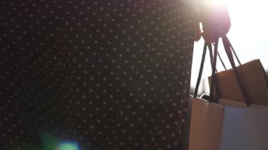 Kadın silahlar alışveriş sonrası alışveriş torbalarını şehir meydanına taşır. Genç bayanın elleri, şehir caddesinde yürürken dolu kağıt paketler tutuyor. Mevsimlik satış ve indirim kavramı. Dolly vurdu.
